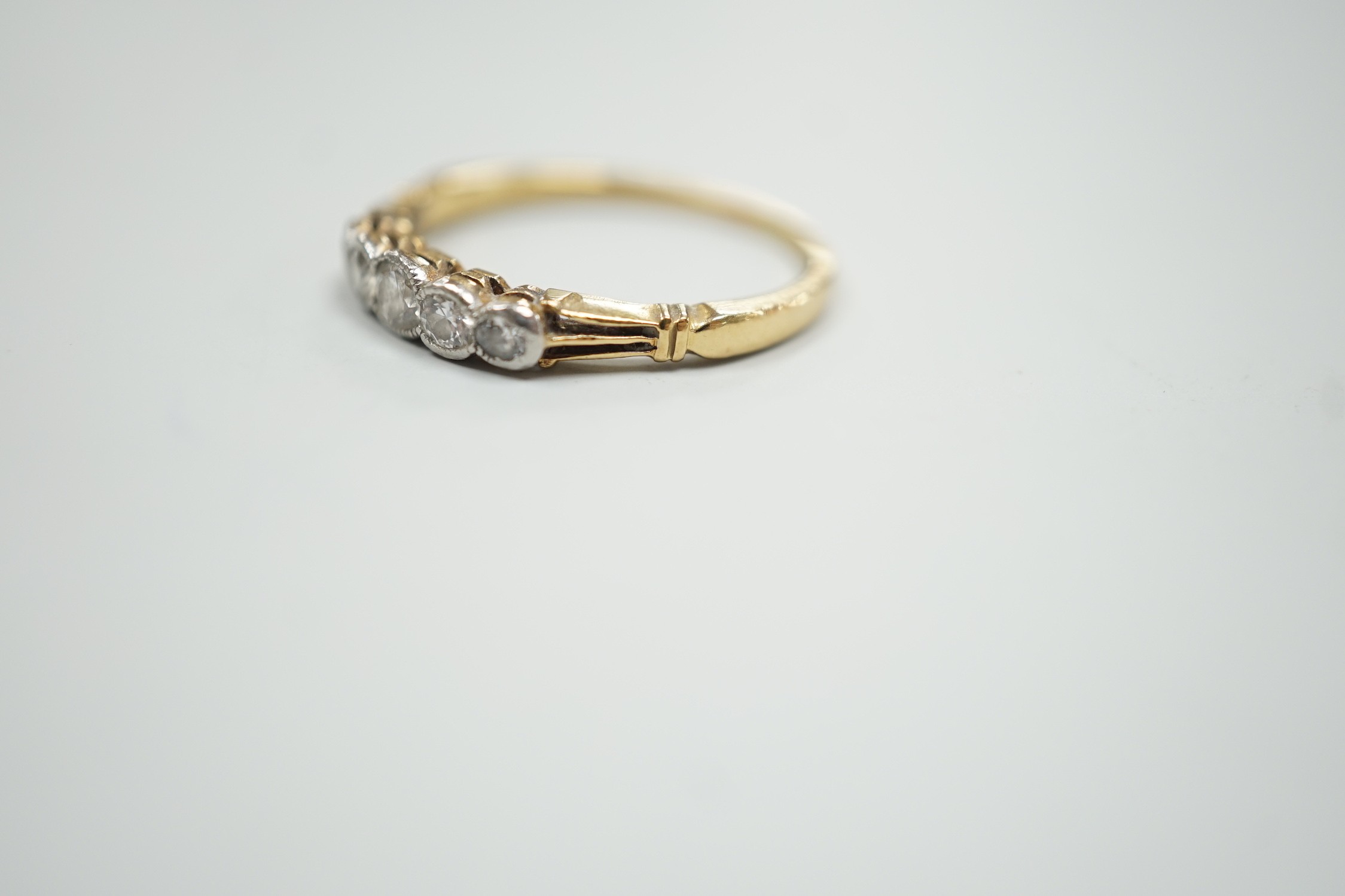 A yellow metal and graduated collet set five stone diamond ring, size N, gross weight 2.2 grams.